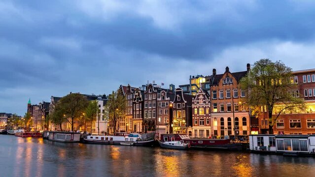 Amsterdam Netherlands time lapse, day to night city skyline at canal waterfront