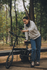 Obraz premium Happy Asian young woman walk and ride bicycle in park, street city her smiling using bike of transportation, ECO friendly, People lifestyle concept.