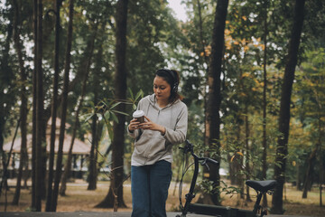 Happy Asian young woman walk and ride bicycle in park, street city her smiling using bike of transportation, ECO friendly, People lifestyle concept.