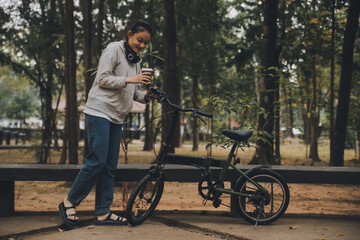 Obraz premium Happy Asian young woman walk and ride bicycle in park, street city her smiling using bike of transportation, ECO friendly, People lifestyle concept.