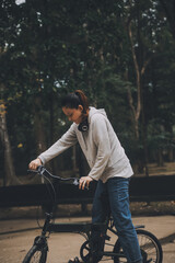 Obraz premium Happy Asian young woman walk and ride bicycle in park, street city her smiling using bike of transportation, ECO friendly, People lifestyle concept.