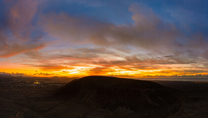 Spectacular sun set image over Volcan Calderon Hondo volcanic crater silhouetted against the setting sun and skyscape near Corralejo, Fuerteventura, Canary Islands, Spain