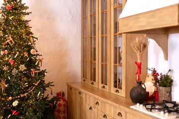 Wooden cases with utensils and decorated Christmas tree near wall in dining room. Rustic Kitchen in...