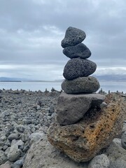 Fototapeta na wymiar stone tower next to the beach in Iceland, calm relaxation and balance. and pollution of the marine ecosystem
