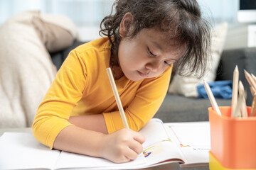 Naklejka na ściany i meble Young girl doing homework at home