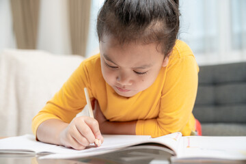 Naklejka premium Young girl doing homework at home