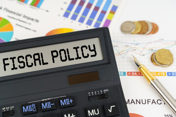 On the table are financial reports, coins and a calculator with the inscription - Fiscal policy