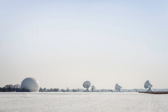 Uplink satellite station in winter landscape with snow and blue skies. 