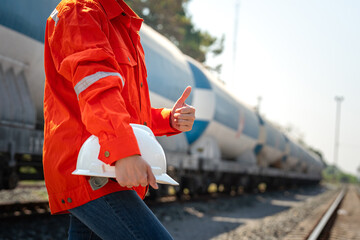Action of a supervisor in orange coverall is thumbs up with holding a white safety helmet on the...