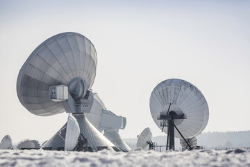 Uplink satellite station in winter landscape with snow and blue skies. 