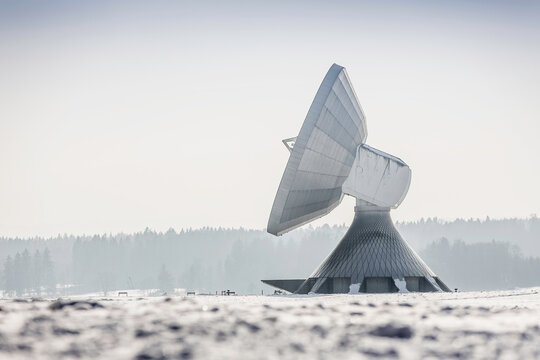 Uplink satellite station in winter landscape with snow and blue skies. 