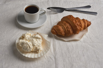 breakfast with croissant and whipped butter in  shell-shaped plate