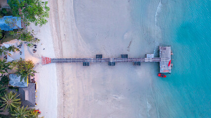 A pier bridge stretching over a sandy beach into the sea, Koh Mak, Trat Province, Thailand.