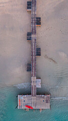 A pier bridge stretching over a sandy beach into the sea, Koh Mak, Trat Province, Thailand.