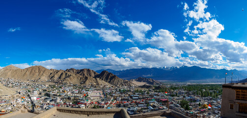 Overlooking Leh town from Leh palace, panoramic view with blue sky and white clouds. The town is located in the valley of the upper Indus River at an elevation of 11,550 feet (3,520 metres).