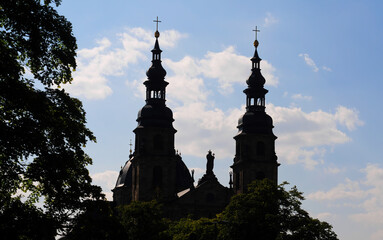 Obraz premium Silhouette of the two towers from the dom or cathedral in Fulda, Hessen, Germany with blue sky and fluffy white clouds on a summer afternoon