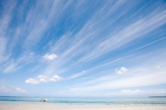 Landscape of beach and large blue sky with yellow boat. Mauritius