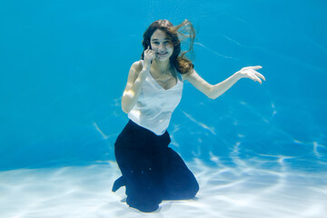 Business woman talking on the phone while swimming underwater