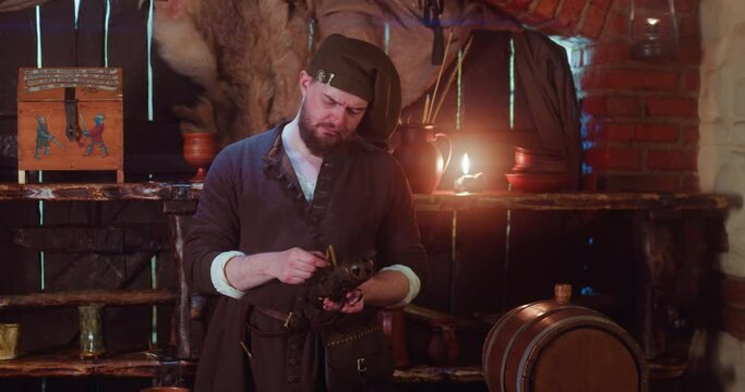 Merchant checks magic herbs in store. Worried bartender in medieval costume holds potion of ingredients in metal container in tavern. Seller secrets