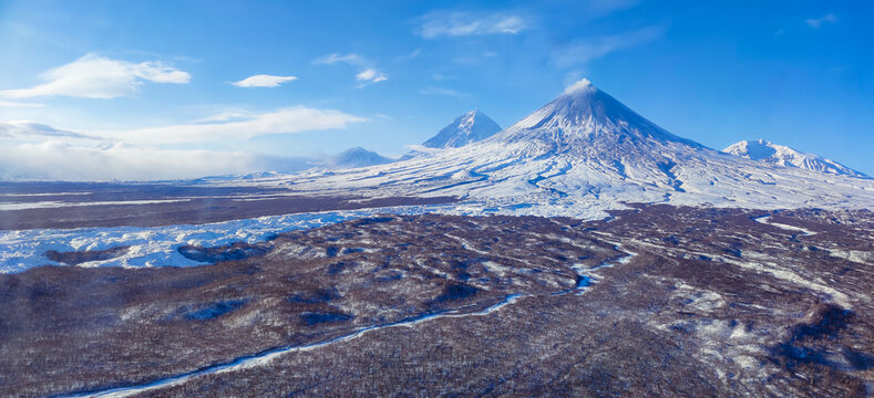 An image of the majestic Klyuchevskaya Sopka, the tallest volcano in Eurasia, towering impressively above the surrounding landscape. For projects related to natural phenomena, geology, adventures. 