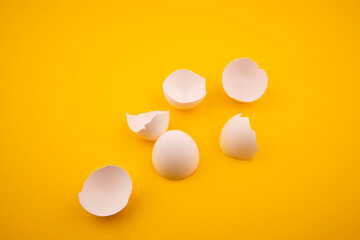 broken white chicken egg shells. broken chicken egg shells on yellow background. broken egg shells