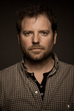 Studio portrait of man with black background. Munich, Germany