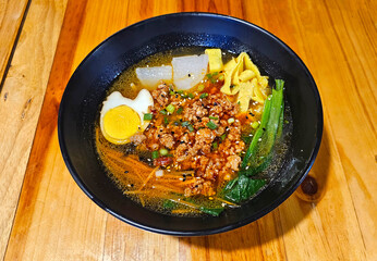 Top view a bowl of minced pork noodles with boiled eggs, carrot,vegetable and Daikon