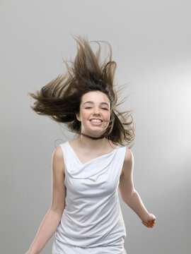 Studio portrait of happy smiling girl with gray background