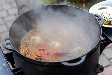 Real Uzbek pilaf in a huge cauldron. Cooking national dishes in Uzbekistan. Rice with meat in a cauldron. Traditional pilaf cooking