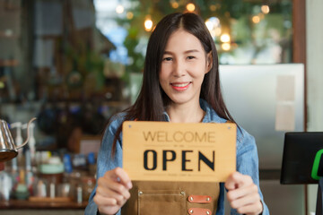 The owner of the cafe beautiful business woman an Asian barista employee Taking photos to promote...