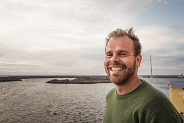 Portrait of man in the midnight sun in Norway with fjord in the background.