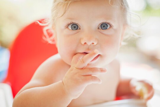 Naklejki Happy baby child eating and laughing in the camera.