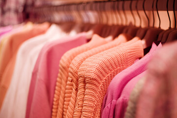 Colorful outerwear on hangers in a clothing store close-up, soft selective focus.