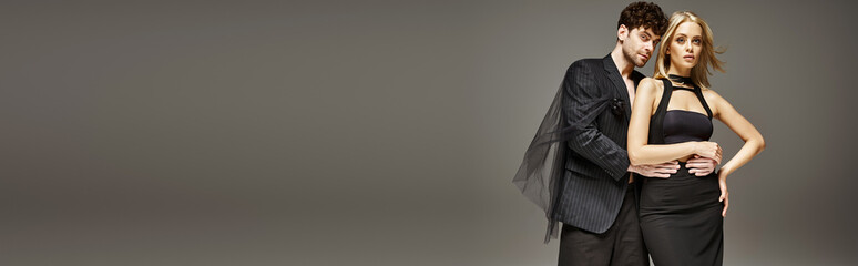 banner of stylish couple in elegant attire, woman in sleek black dress and man in pinstripe suit