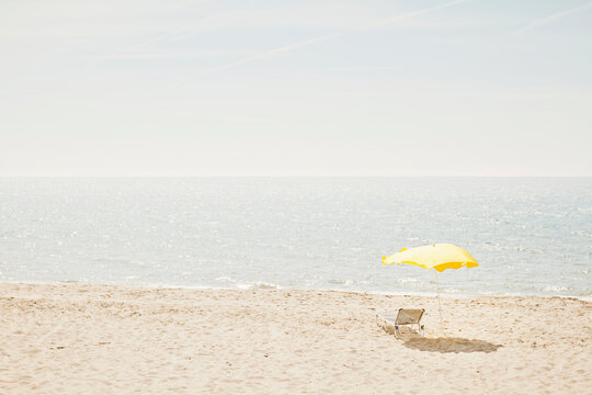 Empty sun chair and umbrella at the beach. Castiglione della Pescaia, Italy