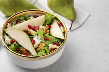Delicious pear salad in bowl on light table, closeup. Space for text