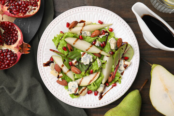 Delicious pear salad with sauce on wooden table, flat lay