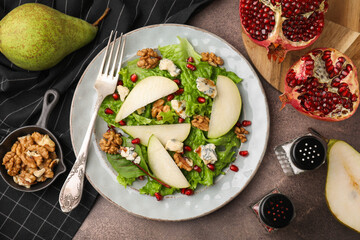 Delicious pear salad served on dark textured table, flat lay