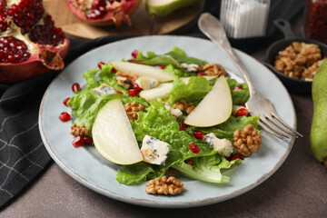 Delicious pear salad on dark textured table, closeup