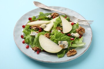 Delicious pear salad on light blue background, closeup