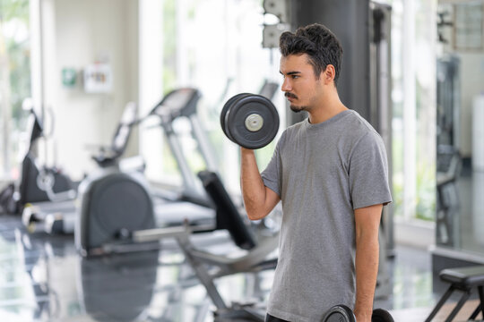 A man in contemplation, preparing to lift weights. This image captures the moment of mental preparation in sports and fitness.Mental preparation for physical activity concept.