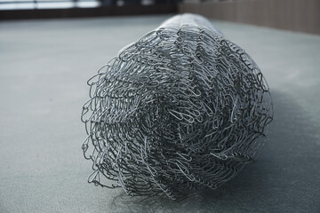 Coil of steel wire. Rabitz mesh netting roll  as background. Construction iron wire or mesh in a...