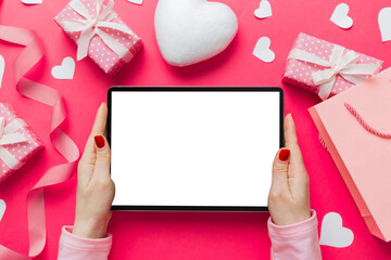 Female hands using a laptop for Valentine day background, gift box and envelope, hearts