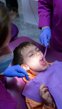 Child at the dentist's office with a dental aspirator