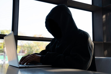 Male hacker in dark room using laptop internet hacking