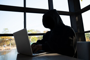 Male hacker in dark room using laptop internet hacking
