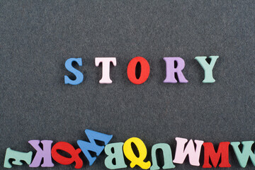 STORY word on black board background composed from colorful abc alphabet block wooden letters, copy space for ad text. Learning english concept.
