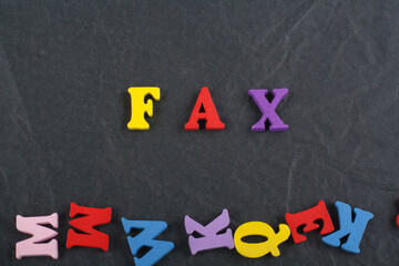 FAX word on black board background composed from colorful abc alphabet block wooden letters, copy space for ad text. Learning english concept.
