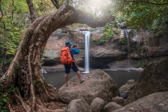 Tourists stand and take photos of the beautiful scenery of Haew Suwat Waterfall. Khao Yai National Park, Thailand.