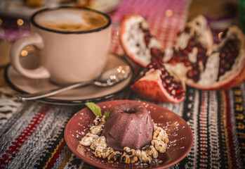 a cup of cocoa, pudding and pomegranate, chocolate puding in the glass with pomegranate.Supangle or pudding